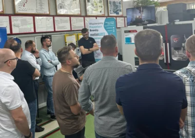 Grupa uczestników obserwuje prezentację działania maszyny CNC w trakcie seminarium organizowanego w CKZiU Nr 2 w Radomiu.