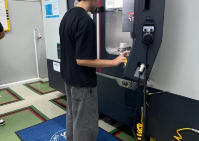 Uczeń ZST Radom obsługuje maszynę CNC SMEC w ramach zajęć w CKZiU2.