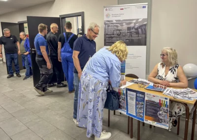 Uczestnicy Dnia Otwartego rozmawiają przy stoisku Branżowego Centrum Umiejętności Nr 2 w Radomiu.